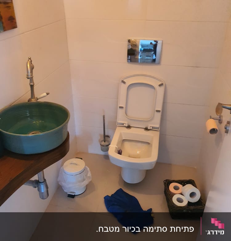 כיור, אסלה, נייר טואלט וכלי עבודה בחדר אמבטיה